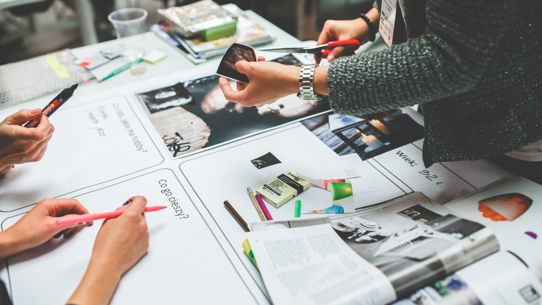 Image of the hands of people working on a magazine