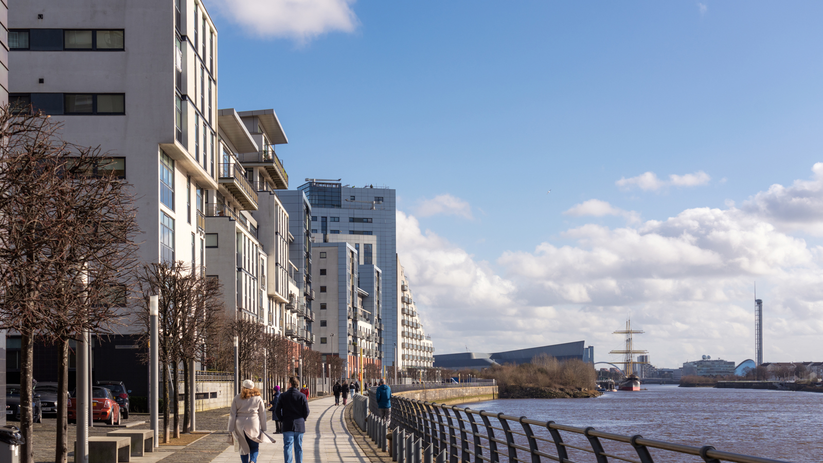 People walking on a pathway next to a river