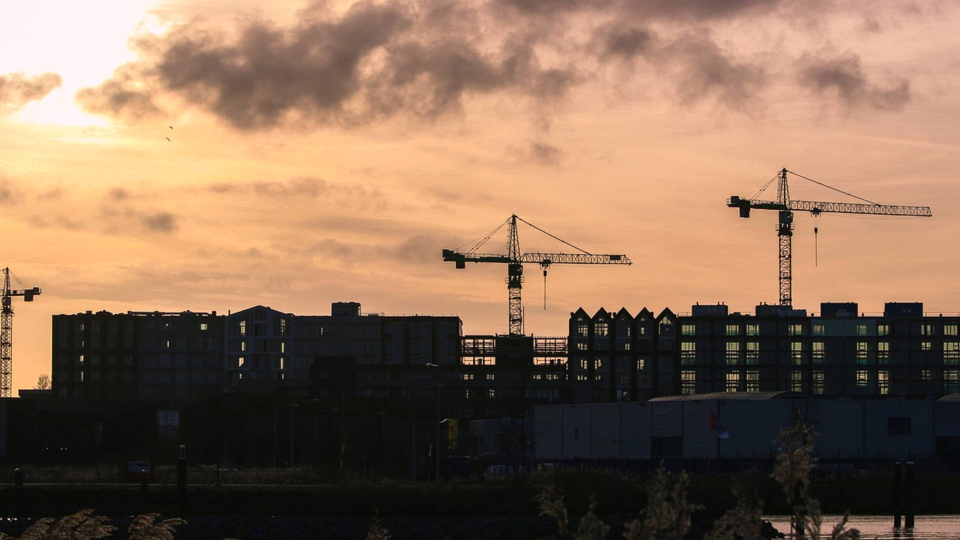 Cranes and buildings being built at dusk